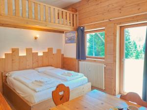 a bedroom with a bed in a wooden room at Valles Vacanze - ski in & ski out in Falcade