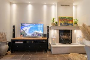a living room with a tv and a fireplace at Villa Ca'Pietra, rustic stone house in Malinska