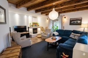 a living room with a blue couch and chairs at Villa Ca'Pietra, rustic stone house in Malinska