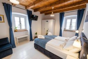 a bedroom with a large bed and two windows at Villa Ca'Pietra, rustic stone house in Malinska +86 photos