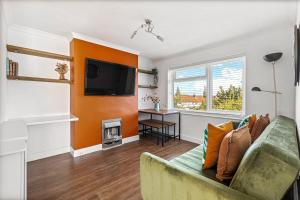 a living room with a couch and a tv at Modern 2-Bed House in Reading in Reading