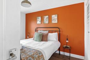 a bed in a room with an orange wall at Modern 2-Bed House in Reading in Reading