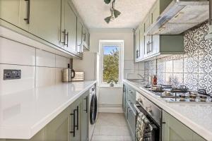 a kitchen with white counter tops and a window at Modern 2-Bed House in Reading in Reading