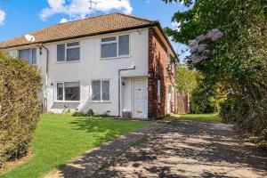 a brick house with a driveway in front of it at Modern 2-Bed House in Reading in Reading