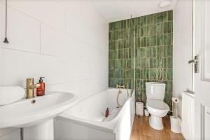 a bathroom with a sink and a tub and a toilet at Modern 2-Bed House in Reading in Reading +17 photos