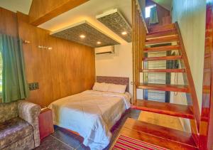 a bedroom with a bed and a staircase in it at JC Den Private Villas Kochi by VOYE HOMES in Cochin +81 photos