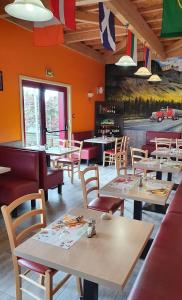 a restaurant with tables and chairs and a painting of a car at The Little Robin in Chevanceaux