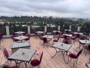 a bunch of tables and chairs on a patio at Hotel Almas Meknes in Meknès