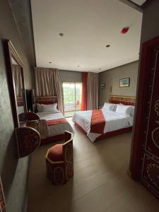 a hotel room with two beds and a window at Hotel Almas Meknes in Meknès +16 photos