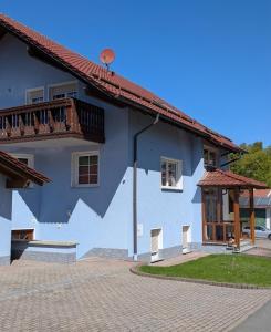 a blue building with a balcony on the side of it at Blaues Häuschen an der Burg in Neuenstein