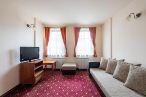 ein Wohnzimmer mit Sofa und Fernseher in der Unterkunft Hotel Hadjiite in Kopriwschtiza