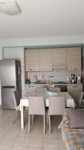 a kitchen with a table and chairs and a refrigerator at Casa al mare Sicilia in Fondachello