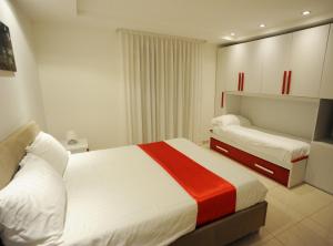 a hotel room with two beds with white and red sheets at THE FLOWERs in Pontecagnano +45 photos