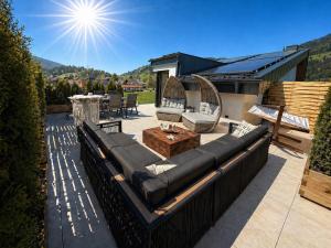 a patio with a couch and a table and chairs at Alpen Sky Suite Flachau in Flachau