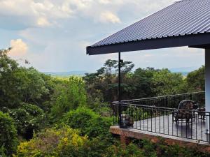 a balcony of a house with a view of the forest at Bushwillows B&B in Rustenburg