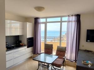 a living room with a table and a view of the ocean at Midia Resort Aheloy in Aheloy
