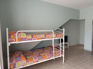 two bunk beds in a room with a staircase at Casa al mare Sicilia in Fondachello