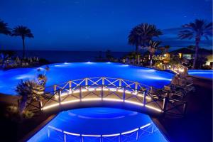 a bridge over a swimming pool at night at R2 Rio Calma in Costa Calma