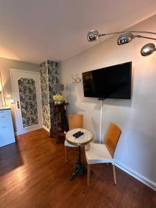 a living room with a table and a tv on a wall at Chez Stéphanie et Sylvain in Le Mesnil-Villeman