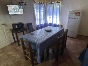a dining room with a table and chairs and a refrigerator at Cabañas Del Sol in Trapiche