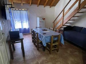 a living room with a table and a blue couch at Cabañas Del Sol in Trapiche