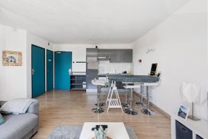 a kitchen and living room with a table and a couch at Le Cabano'scope in Chasseneuil-du-Poitou