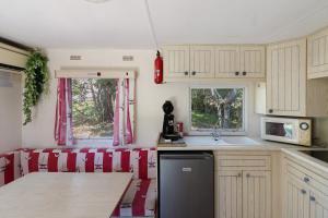a kitchen with white cabinets and a counter with a sink at Mobilehome chez dede in Porto-Vecchio