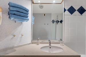a bathroom with a sink and a shower with blue towels at Le Cabano'scope in Chasseneuil-du-Poitou +15 photos