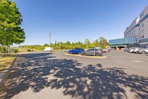 a parking lot with cars parked in front of a building at Le Cabano'scope in Chasseneuil-du-Poitou