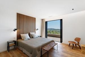 a bedroom with a bed and a large window at Villa Schena Villata in Zonza +31 photos