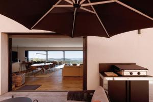 a kitchen and living room with a large black umbrella at Villa Schena Villata in Zonza