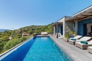 a villa with a swimming pool and a house at Villa Schena Villata in Zonza