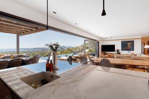 a kitchen and living room with a view of a pool at Villa Schena Villata in Zonza