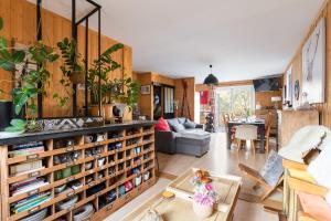 a living room with a large book shelf with books at Chalet le 22 Agniéres in Le Dévoluy