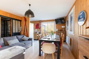 a living room with a table and a couch at Chalet le 22 Agniéres in Le Dévoluy