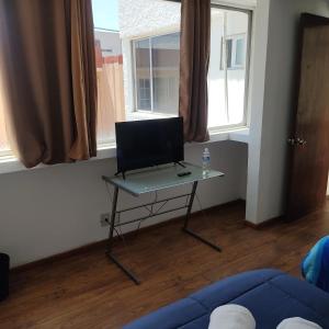a table with a laptop on it in a living room at Suites Casa Blanca Metepec in Toluca