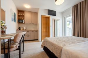 a bedroom with a bed and a table and a kitchen at Apartmani IVA in Neum