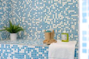 a blue tiled bathroom with a towel and a plant at Italian Experience-Casale Oleandro Marino in Porto Recanati