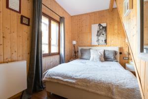 a bedroom with a bed in a wooden wall at Chalet le 22 Agniéres in Le Dévoluy