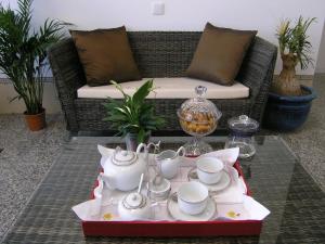 a coffee table with tea cups and saucers on a couch at Casa de Alpajares - Guest House & Spa in Freixo de Espada à Cinta