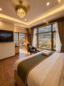 a bedroom with a large bed and a large window at Hotel Oscar By Ginger Hotels Chain Near Club House Road Manali Luxury Rooms Best Hotel In Manali !!!!! in Manāli +9 photos