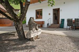a statue of an owl sitting on a rock next to a tree at Holderstanzenhof in Bad Griesbach