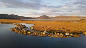 an island in the middle of a body of water at Titicaca Uros Atardecer in Puno