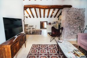 a living room with a flat screen tv and a couch at La Casa del Boticario in Alcalá del Júcar