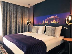 a bedroom with a large bed with a painting on the wall at Mercure Salzburg City in Salzburg +57 photos