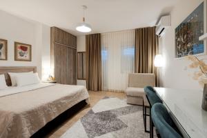 a bedroom with a bed and a table and a chair at Apartmani IVA in Neum