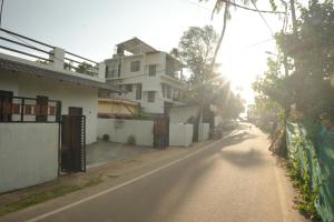 an empty street with a house and a fence at Dune Hostel - Dune Homestay in Alleppey