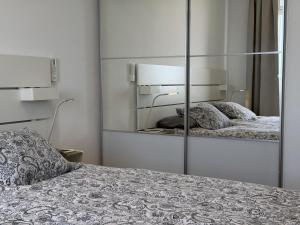 a bedroom with a mirror next to a bed at AMADORES BEACH VIEW APARTMENT in Amadores