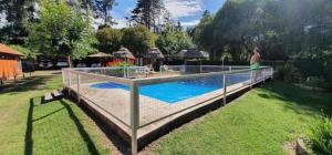 a man is standing next to a swimming pool at Cabañas Del Sol in Trapiche +21 photos