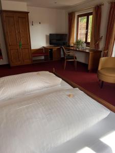 a bedroom with a white bed and a desk at Parkhotel Krone Maleck in Emmendingen